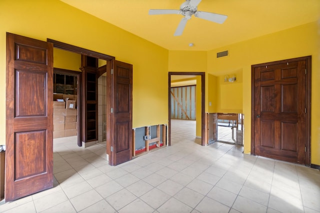 empty room featuring ceiling fan and light tile patterned floors