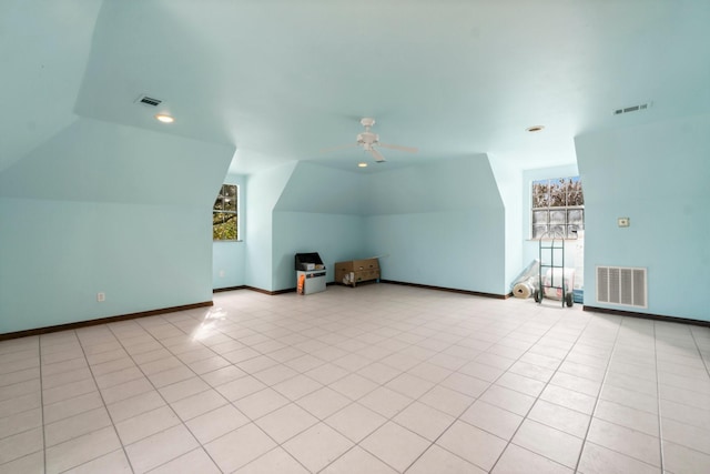 bonus room with ceiling fan, plenty of natural light, light tile patterned flooring, and lofted ceiling