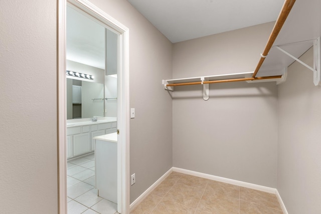 spacious closet with sink and light tile patterned floors