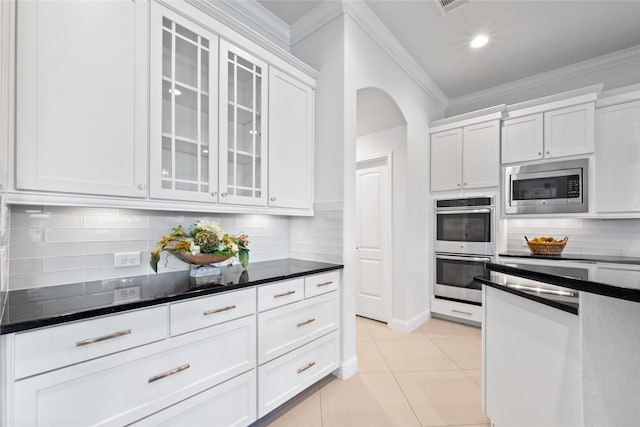 kitchen featuring white cabinets, appliances with stainless steel finishes, and tasteful backsplash