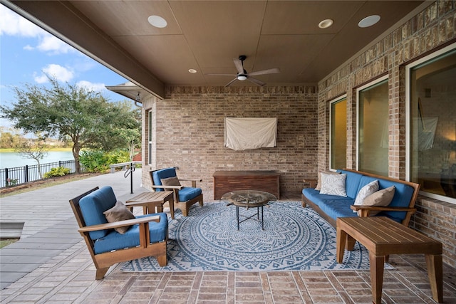 view of patio / terrace with ceiling fan, a water view, and an outdoor hangout area