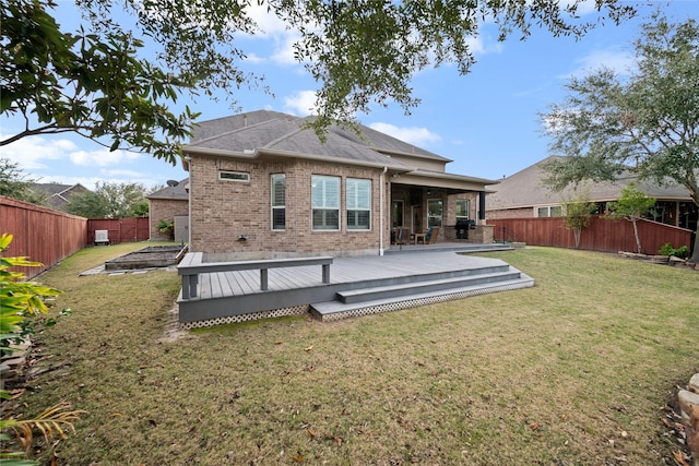 rear view of house featuring a yard and a wooden deck