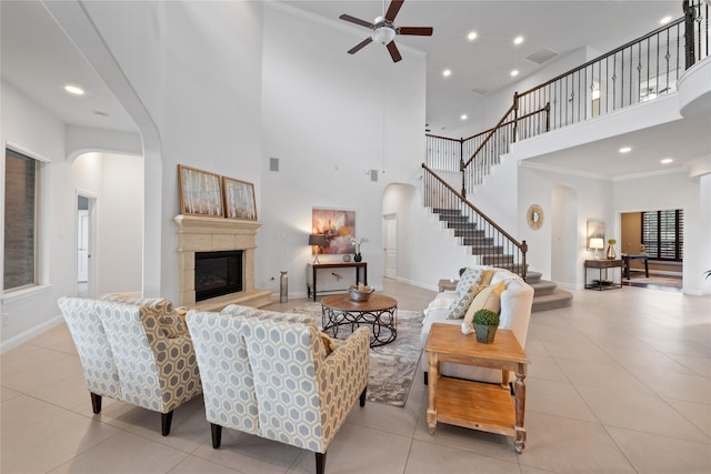 living room featuring ceiling fan, a towering ceiling, and light tile patterned floors