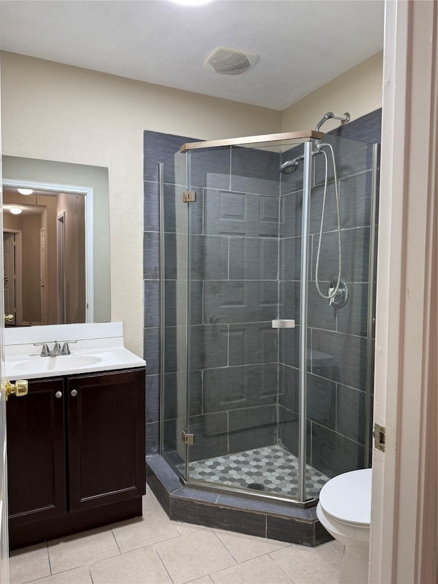 bathroom featuring tile patterned floors, vanity, toilet, and walk in shower