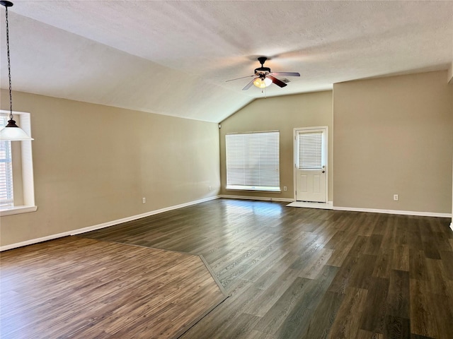 bonus room with a textured ceiling, ceiling fan, dark wood-type flooring, and vaulted ceiling