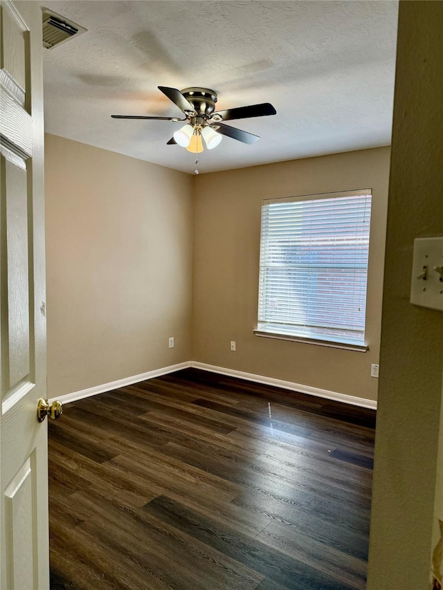 unfurnished room with a textured ceiling, ceiling fan, and dark wood-type flooring