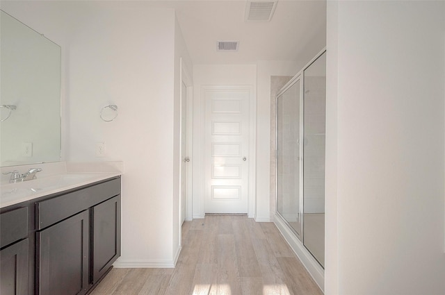 bathroom with vanity, an enclosed shower, and hardwood / wood-style flooring