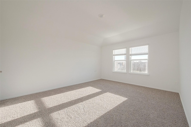 carpeted spare room with lofted ceiling