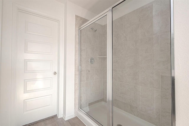 bathroom featuring a shower with door and hardwood / wood-style flooring