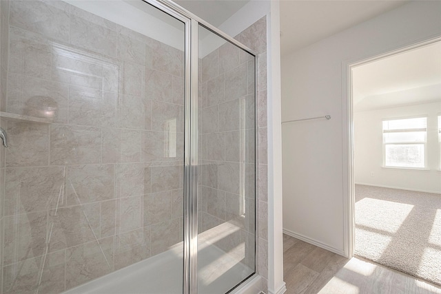 bathroom featuring wood-type flooring and an enclosed shower