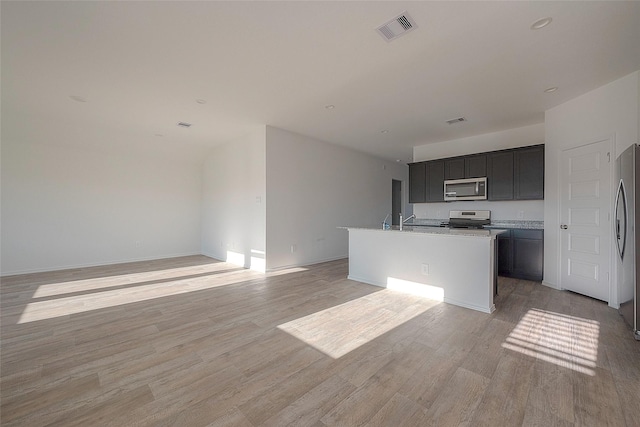 kitchen with stainless steel appliances, a kitchen island with sink, light hardwood / wood-style floors, and sink