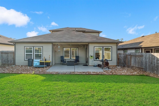 rear view of property featuring a lawn and a patio