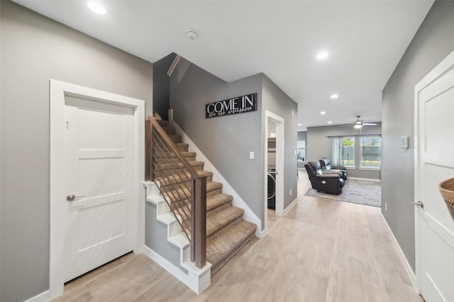 foyer entrance featuring ceiling fan, washer / dryer, and light wood-type flooring