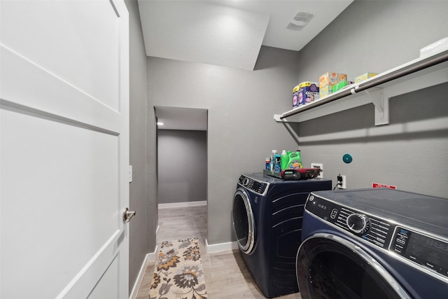 clothes washing area with light hardwood / wood-style flooring and independent washer and dryer