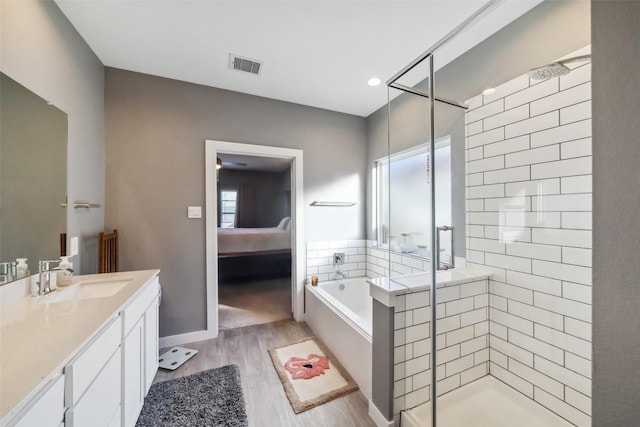 bathroom with plenty of natural light, vanity, hardwood / wood-style floors, and shower with separate bathtub