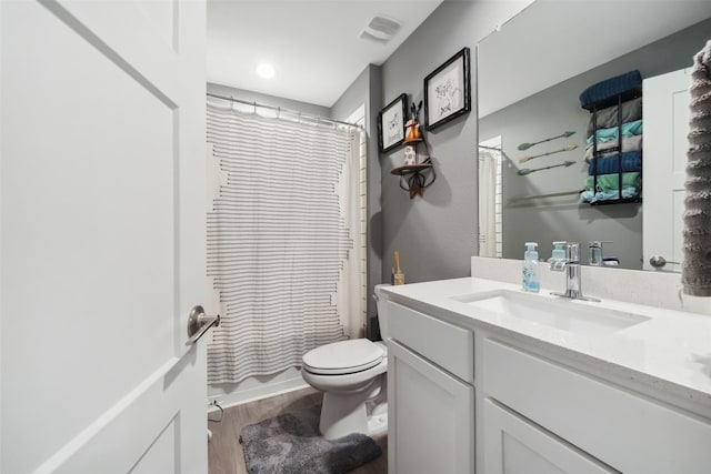 bathroom featuring curtained shower, hardwood / wood-style floors, vanity, and toilet