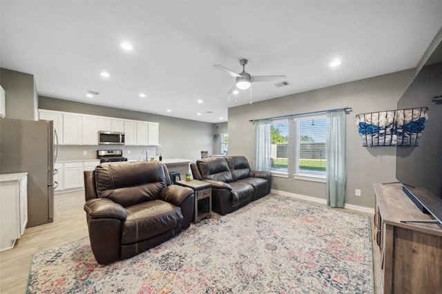 living room with light wood-type flooring and ceiling fan