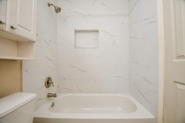 bathroom featuring tiled shower / bath combo and toilet