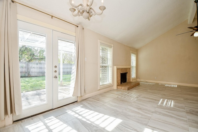 unfurnished living room with ceiling fan with notable chandelier, lofted ceiling, and french doors