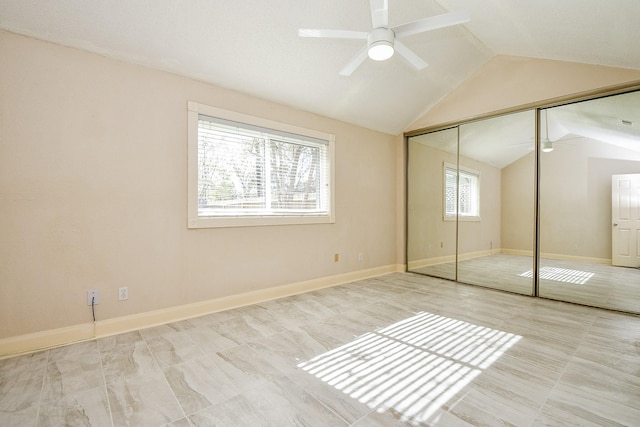 unfurnished bedroom with vaulted ceiling, a closet, and ceiling fan