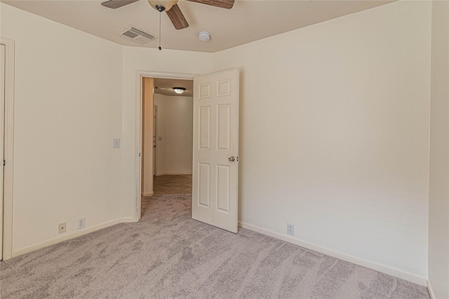 spare room with light colored carpet and ceiling fan