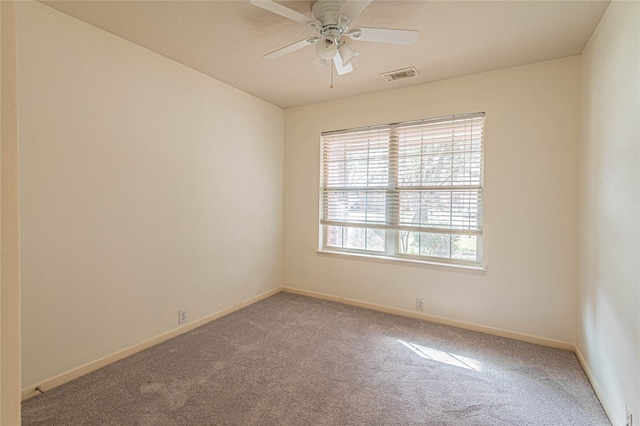 carpeted spare room featuring ceiling fan