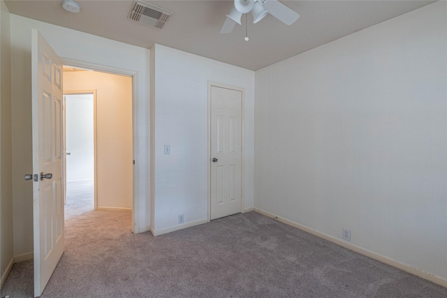 unfurnished bedroom with a closet, light colored carpet, and ceiling fan