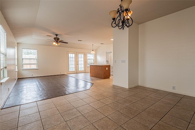 tiled empty room featuring ceiling fan with notable chandelier