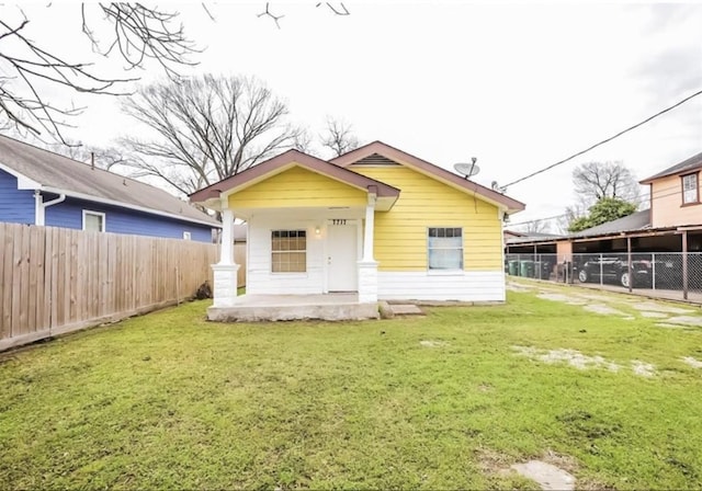 back of property with a porch and a yard