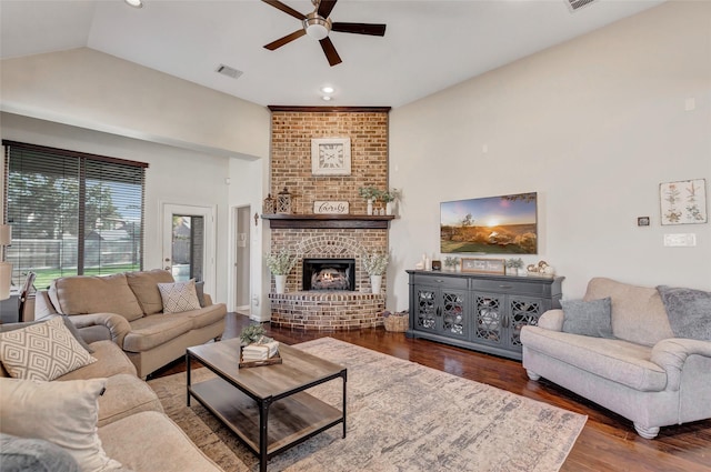 living room featuring a fireplace, dark hardwood / wood-style flooring, vaulted ceiling, and ceiling fan