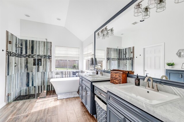 bathroom with vanity, vaulted ceiling, and separate shower and tub