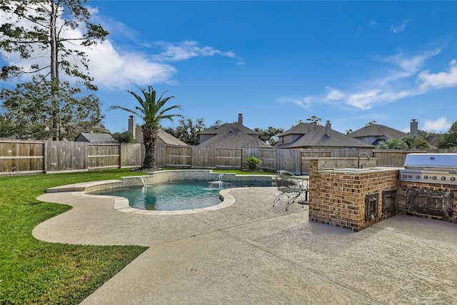 view of swimming pool with an outdoor kitchen, an outdoor bar, grilling area, pool water feature, and a patio area