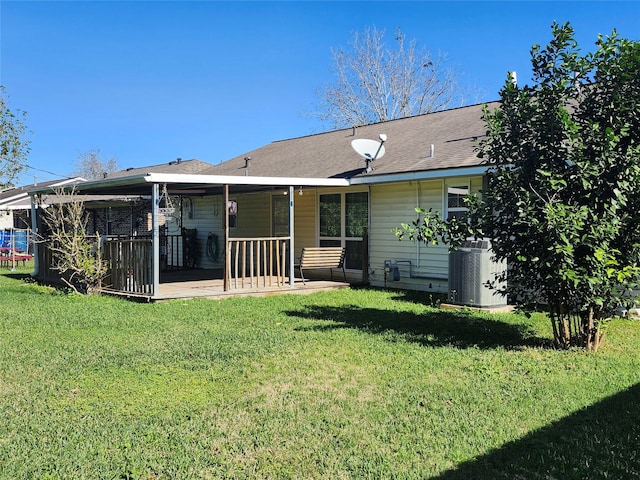 rear view of property with a lawn and cooling unit