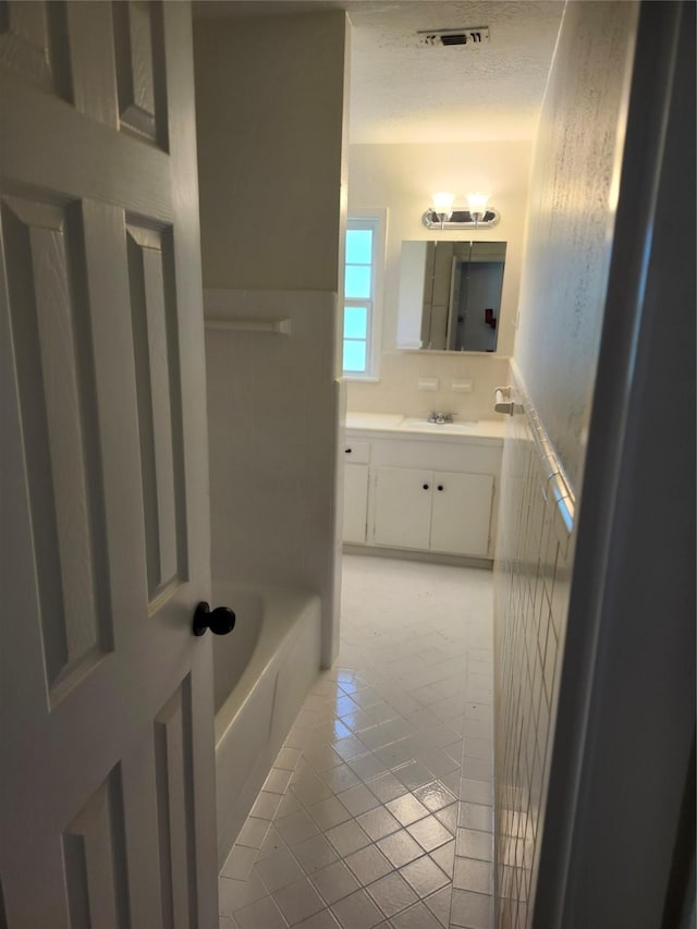 bathroom with vanity, tile patterned floors, and a bathtub