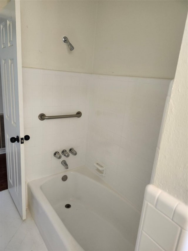 bathroom with tile patterned flooring and a tub to relax in