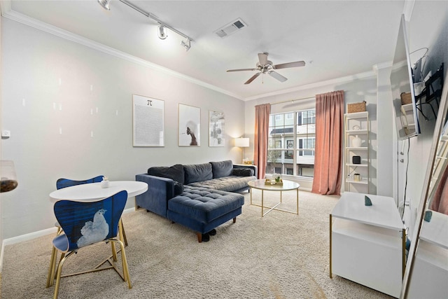 living room with ceiling fan, track lighting, crown molding, and carpet flooring