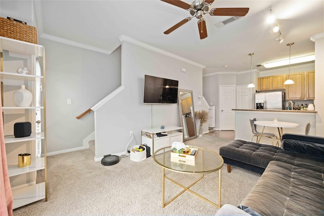 living room featuring ceiling fan, light colored carpet, and crown molding