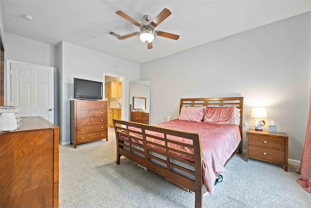 carpeted bedroom with ceiling fan and connected bathroom