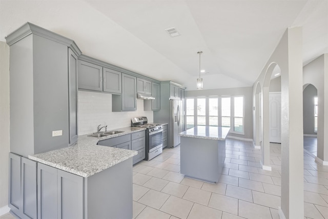 kitchen featuring sink, backsplash, kitchen peninsula, lofted ceiling, and appliances with stainless steel finishes