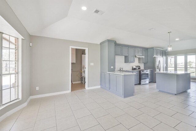 kitchen featuring decorative light fixtures, kitchen peninsula, stainless steel appliances, and light tile patterned floors