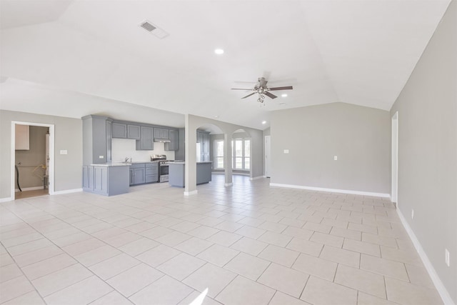 unfurnished living room with ceiling fan, lofted ceiling, and light tile patterned floors