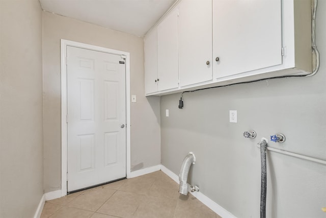 clothes washing area with electric dryer hookup, cabinets, light tile patterned floors, and hookup for a washing machine