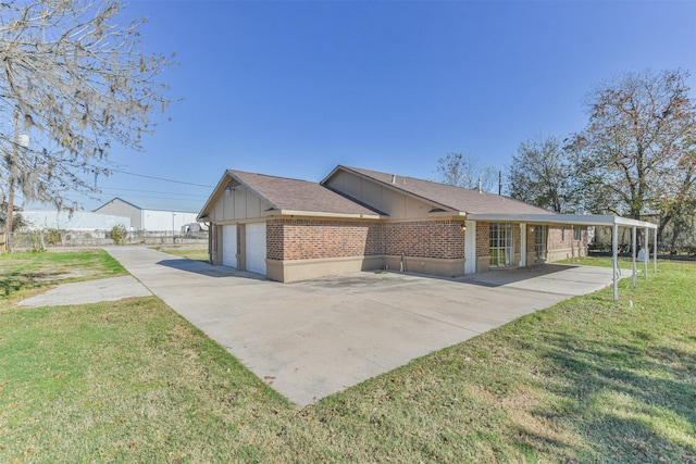 exterior space with a garage, a carport, and a lawn