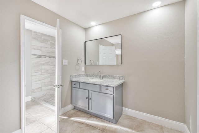 bathroom with tile patterned floors, vanity, and tiled shower