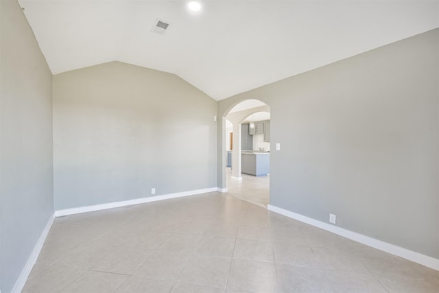 tiled spare room with lofted ceiling