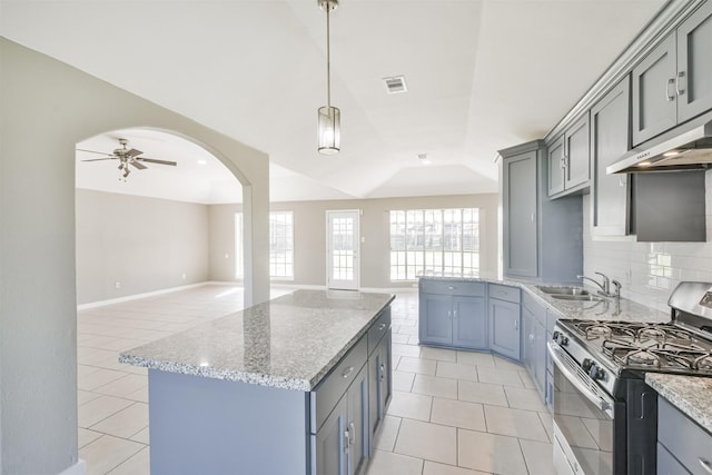 kitchen featuring gas range, ceiling fan, sink, lofted ceiling, and decorative backsplash