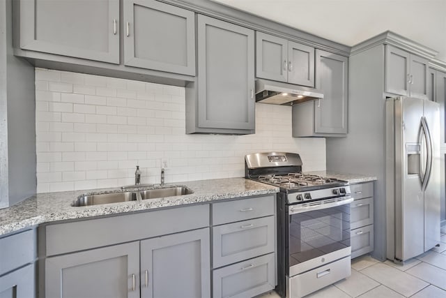 kitchen featuring sink, tasteful backsplash, light tile patterned flooring, light stone counters, and stainless steel appliances