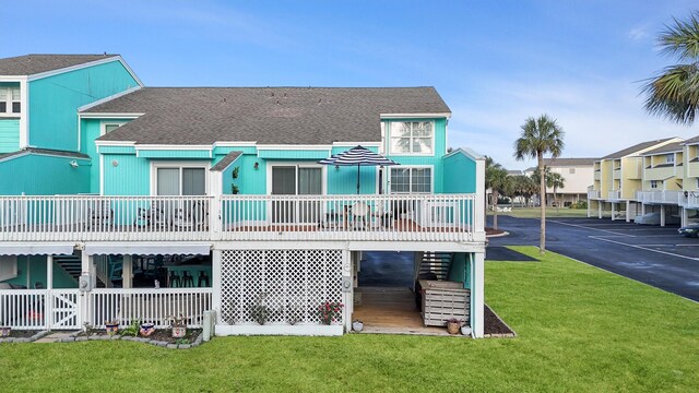 back of house featuring a carport and a lawn