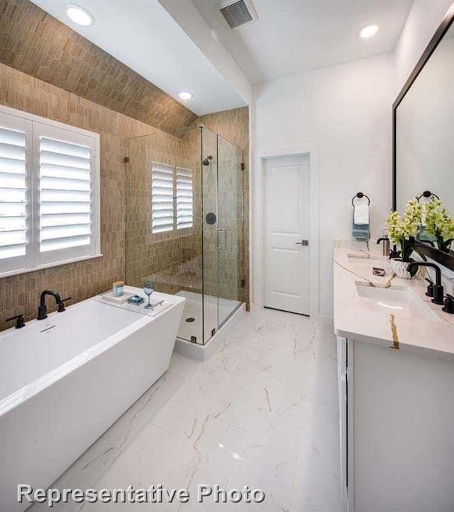 bathroom featuring vanity, tile walls, shower with separate bathtub, and vaulted ceiling