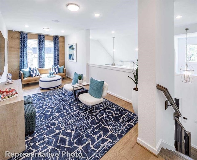 sitting room with hardwood / wood-style flooring, a healthy amount of sunlight, and a chandelier